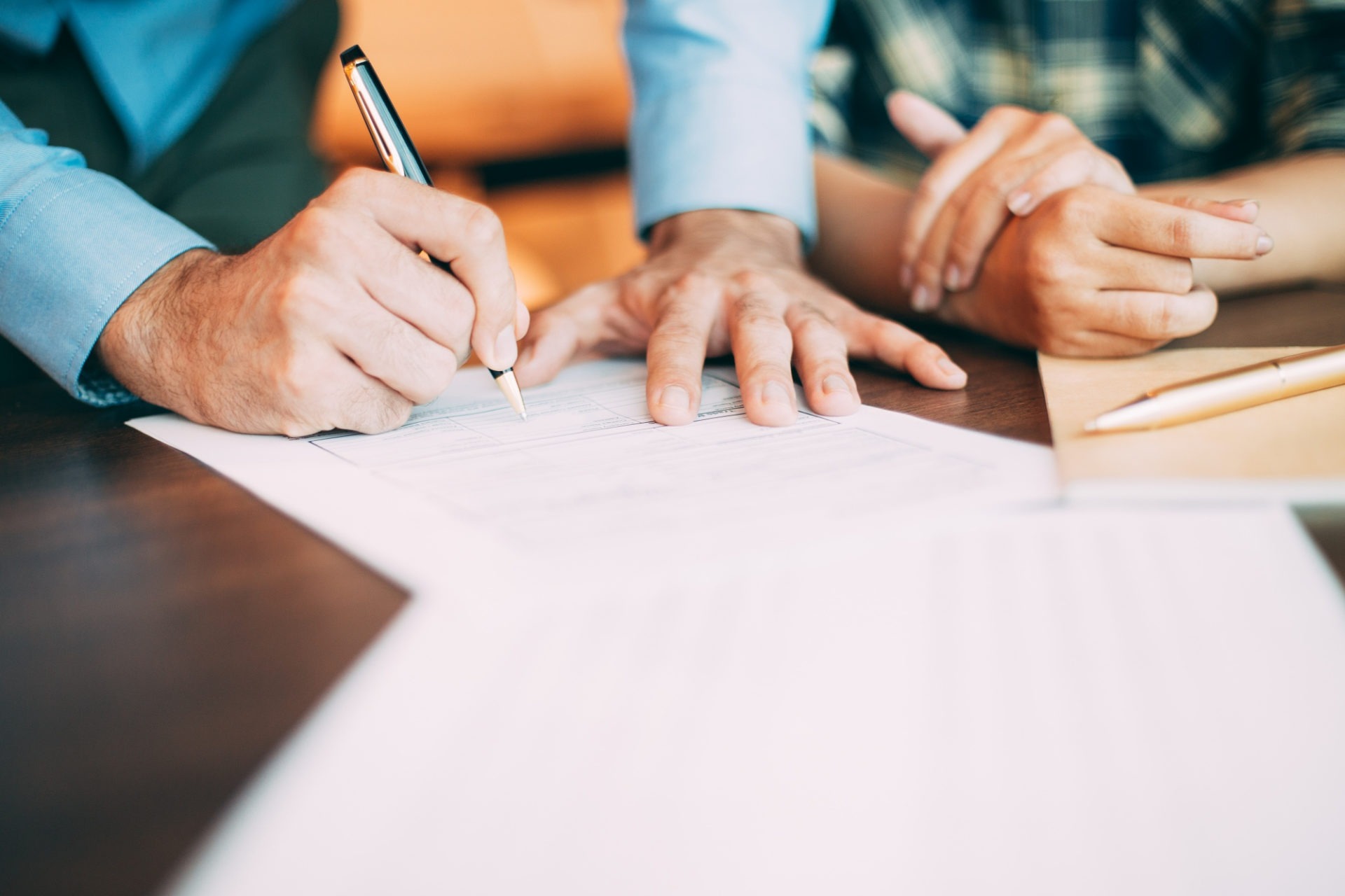 Droit du travail - Gros plan sur les mains de deux personnes, dont une signant un contrat