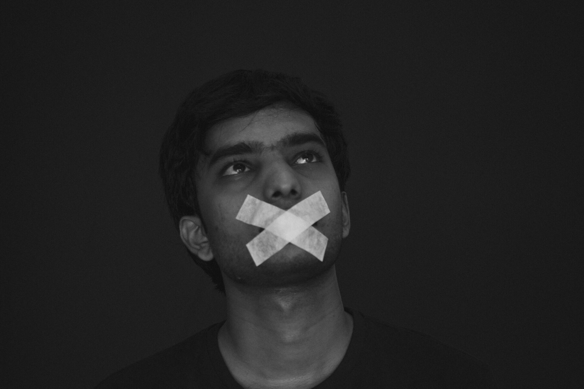 Jeune homme avec du papier collant sur la bouche